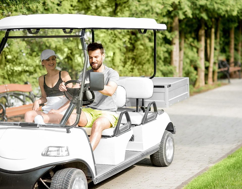 A couple driving a golf cart